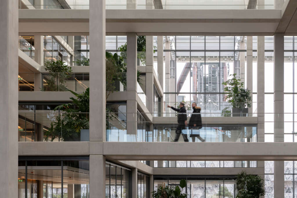 ICÔNE Foster + Partners Atrium desain arsitektur gedung perkantoran Belval Luxembourg dengan jembatan penghubung yang menghadap ke lanskap industri warisan di baliknya