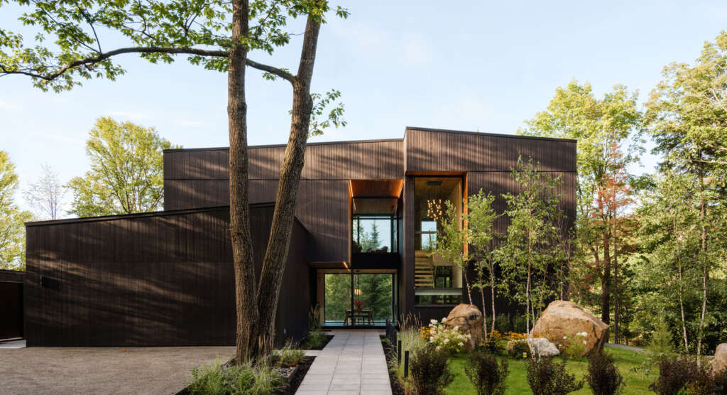 Rumah liburan desain Arsitektur MU di Quebec menampilkan pintu masuk yang dipahat di antara volume seperti batu